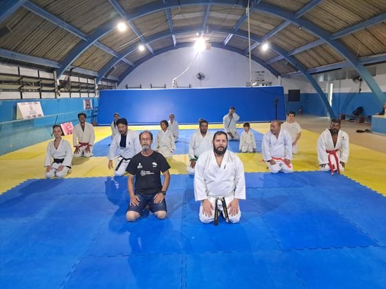 Alunos de várias idades ajoelhados em seiza no fim da aula, no ginásio do CEE Cambuci